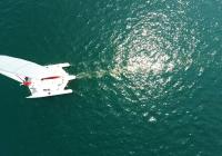 photo aérienne nadir réflexion du soleil trimaran voiles sur la mer